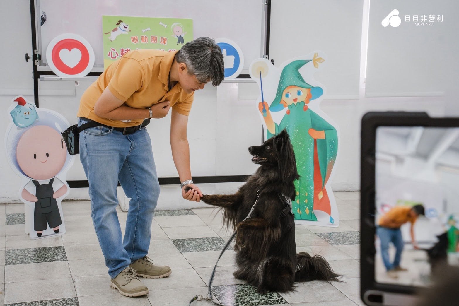 帶領人員在課程現場與黑色長毛犬練習握手
